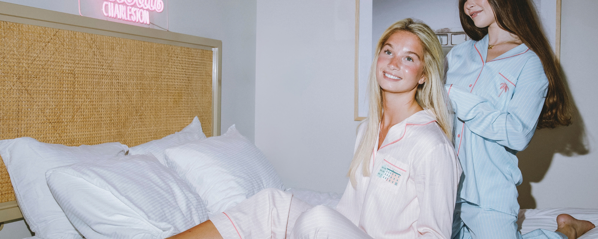 two girls wearing pajamas on bed